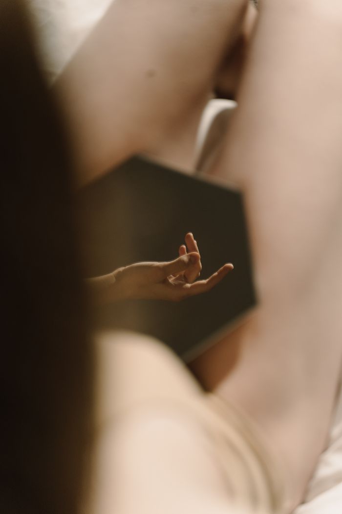 Soft focus on a hands reflection in an intimate and elegant nude setting.